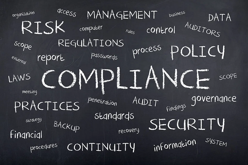 Compliance binders next to a padlock — paperwork is not protection.