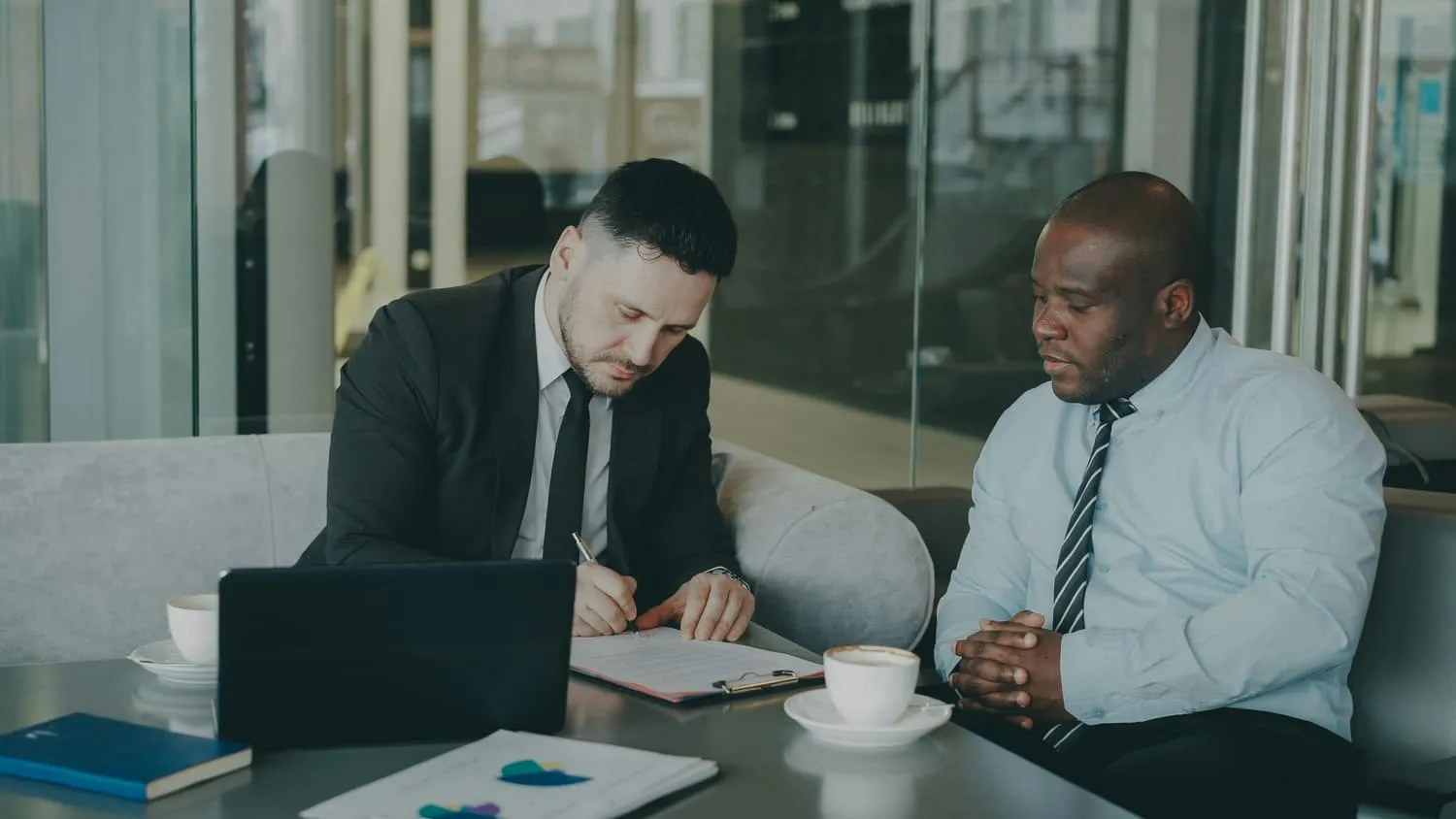 Two executives reviewing a document together at a meeting table — the considered evaluation a vCISO hire deserves.